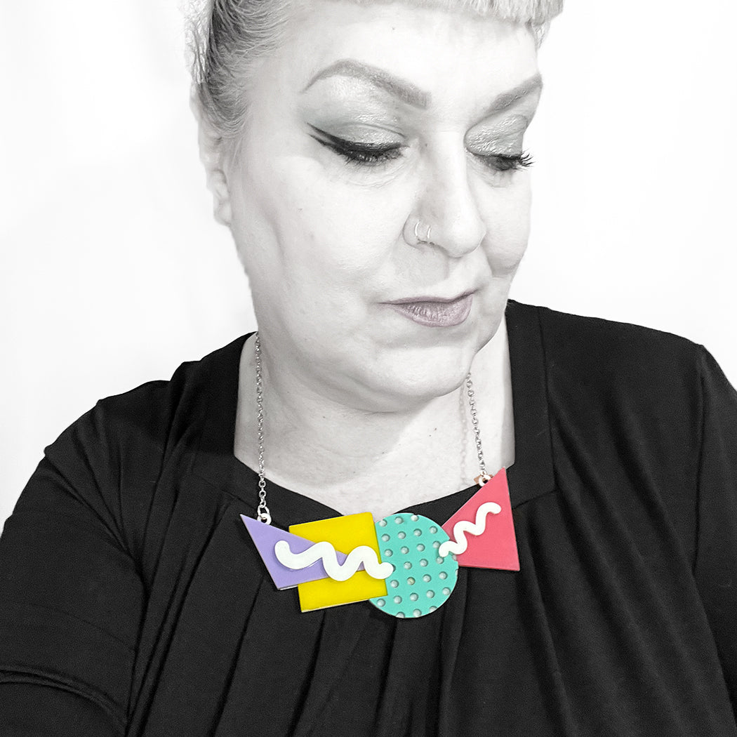 Woman wearing large pastel 80s necklace.