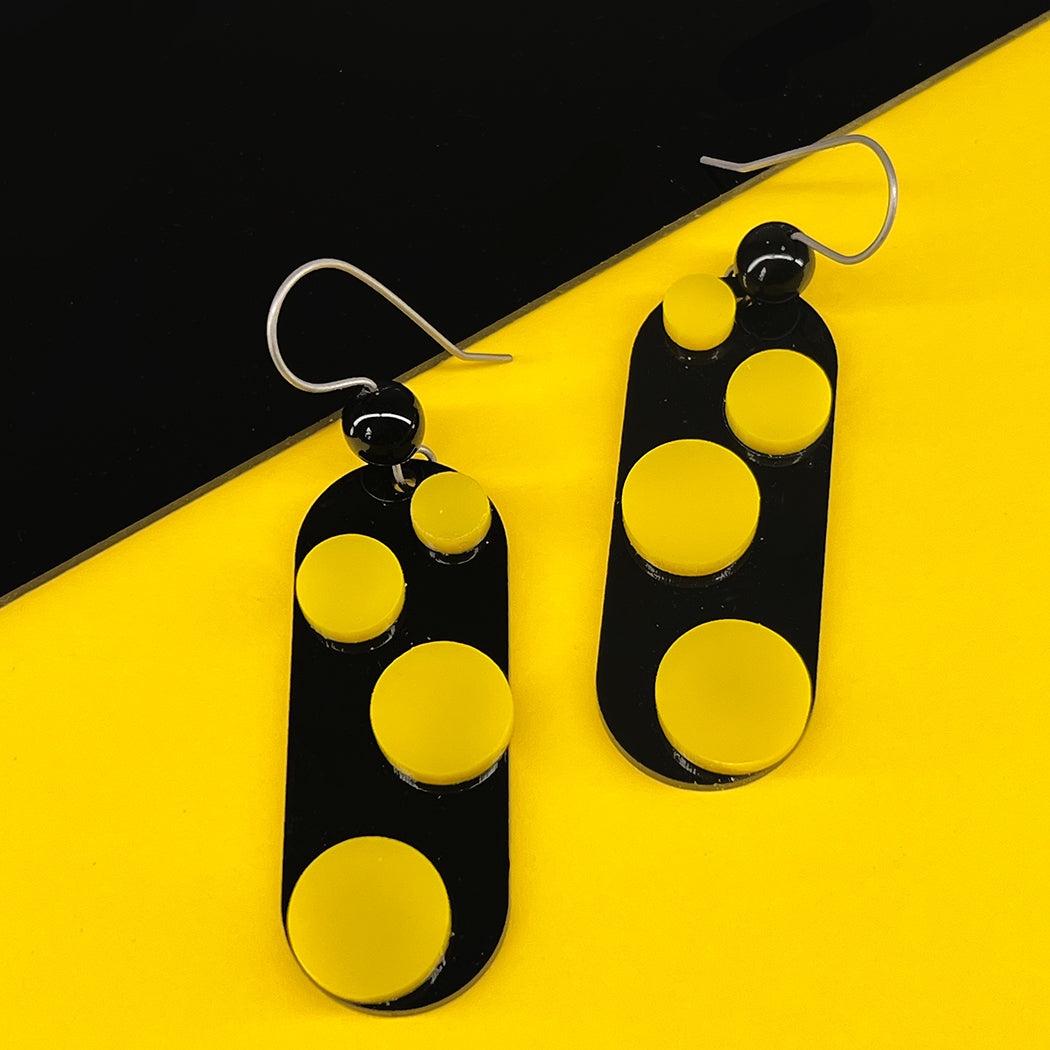Close up of black and yellow Infinite Dot Love Earrings from by Barbe  Jewelry