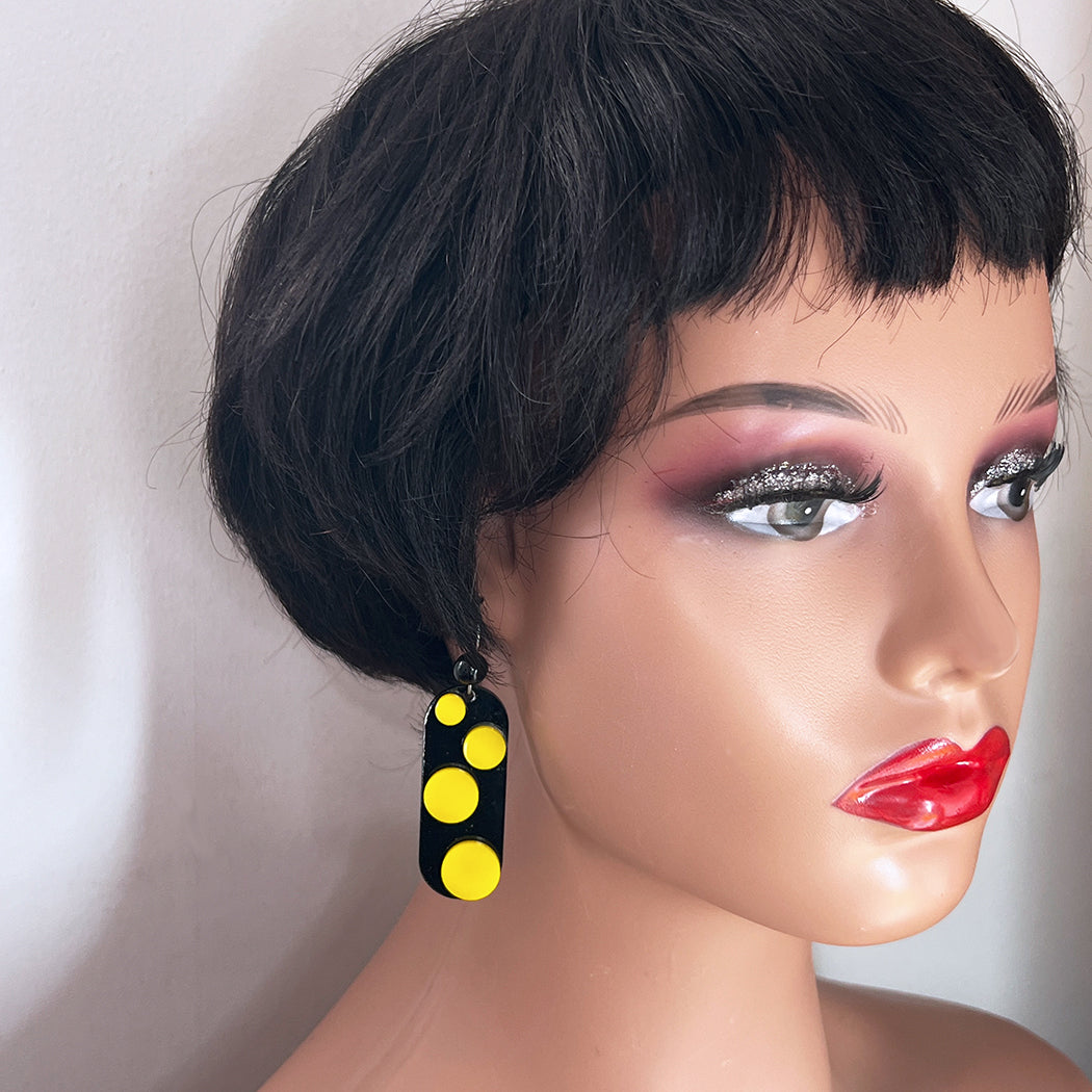 Mannequin wearing black and yellow polka dot earring from Barbe Saint John. 